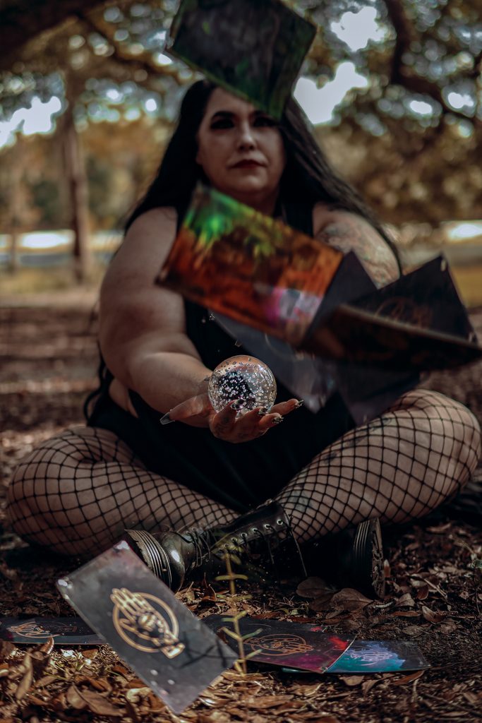 Dark fantasy model gazing into a glass sphere, capturing reflective crystal scrying dynamics in a witchy Central Florida portrait.